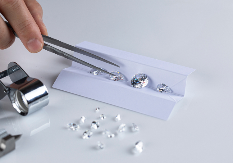 loose diamonds, one is being held by a tweezers